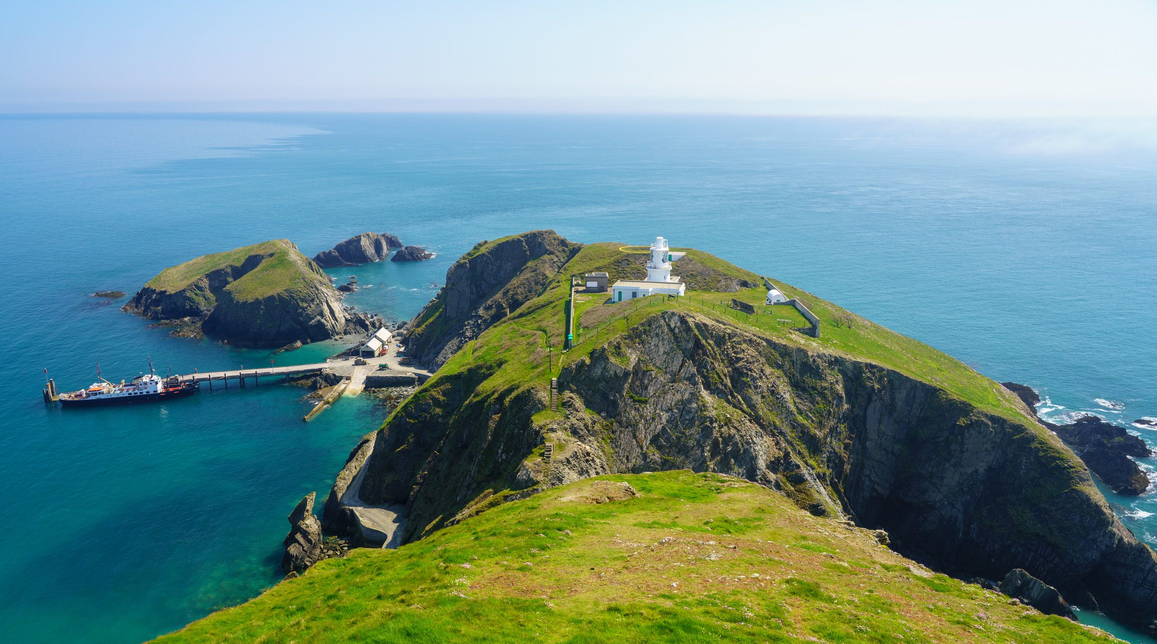 Aerial view of Lundy lighthouse and the dock where boats arrive