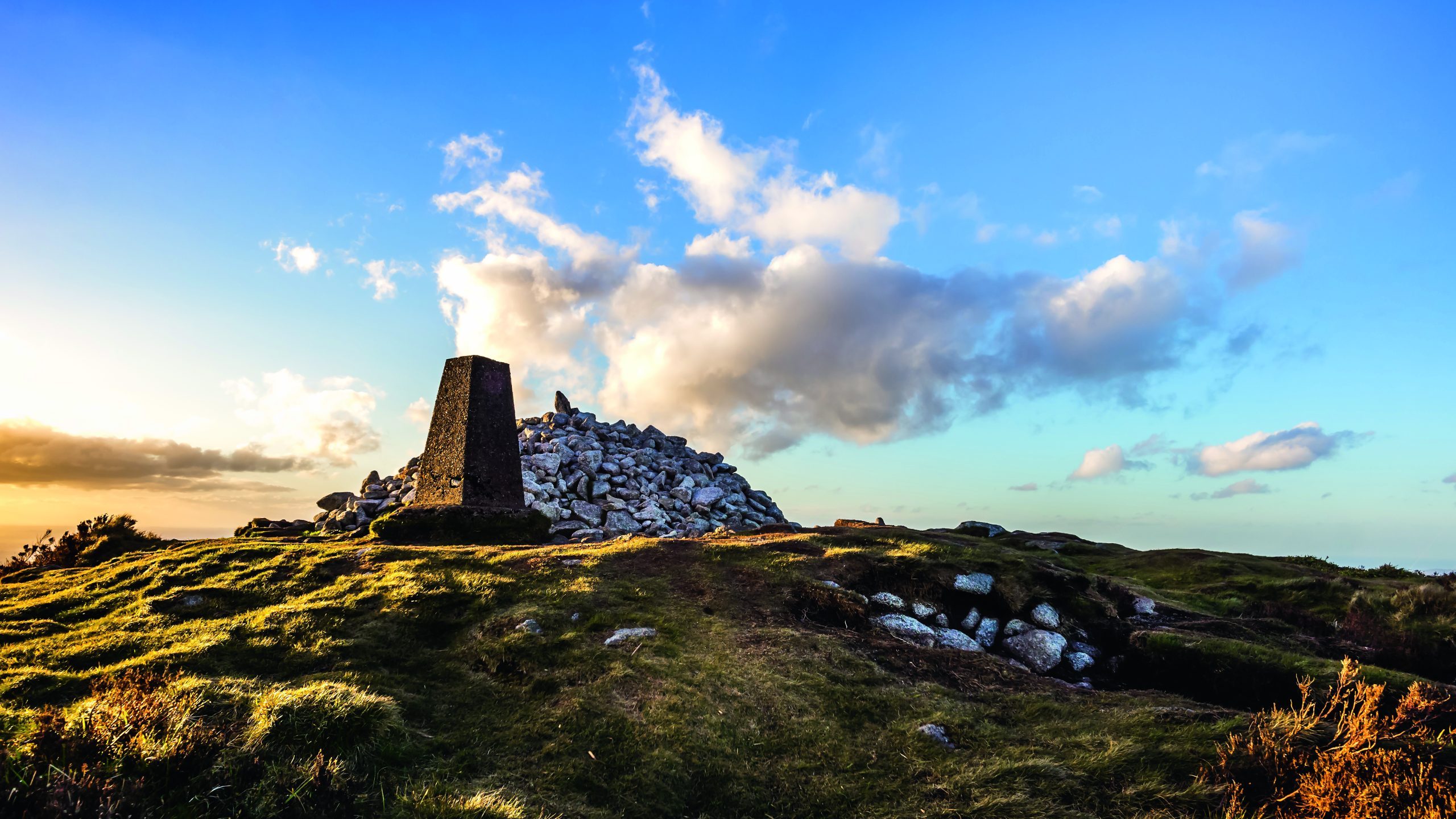 Beautifully sunset at Ticknock hill in Wicklow mountains with pile of stones called Fairy Castle and stone landmark, golden hour, Ireland