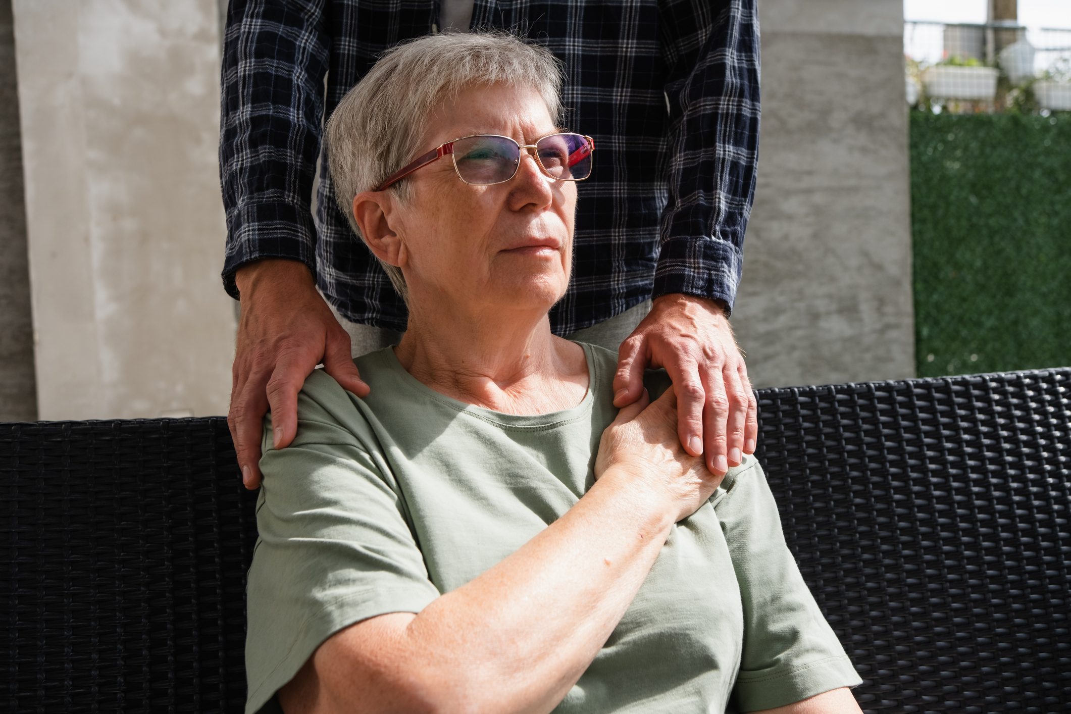 An older person receiving help from someone behind them