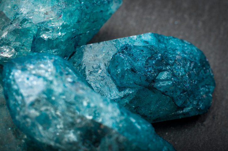 Macro image of raw jewels Closeup of a bunch of many blue rough uncut sapphire crystals