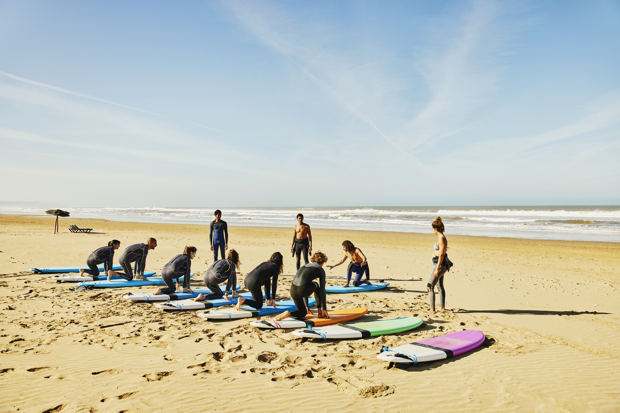 A group of people learning to surf on a beach
