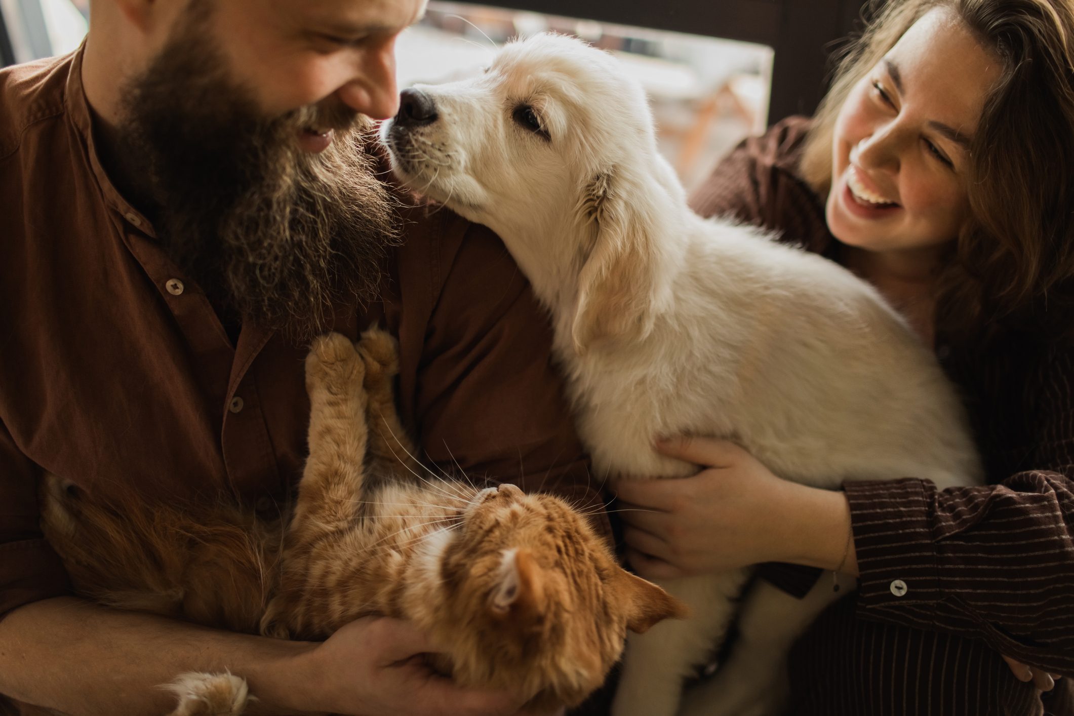 A dog licking its owner while they smile happily 