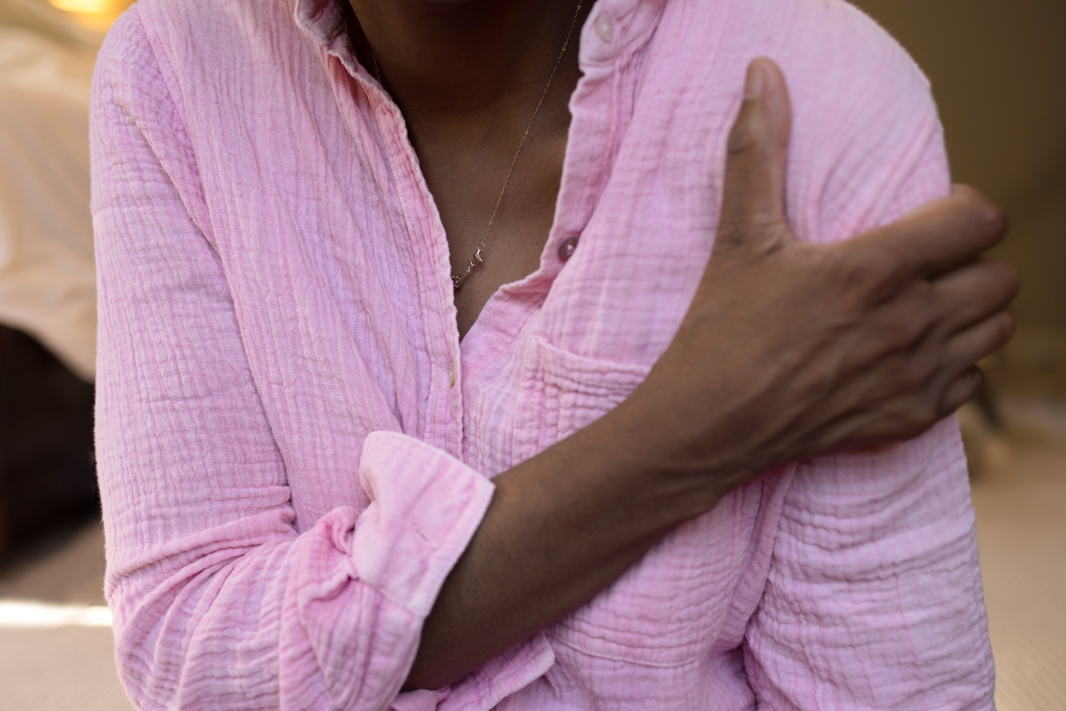 A woman clutching her shoulder