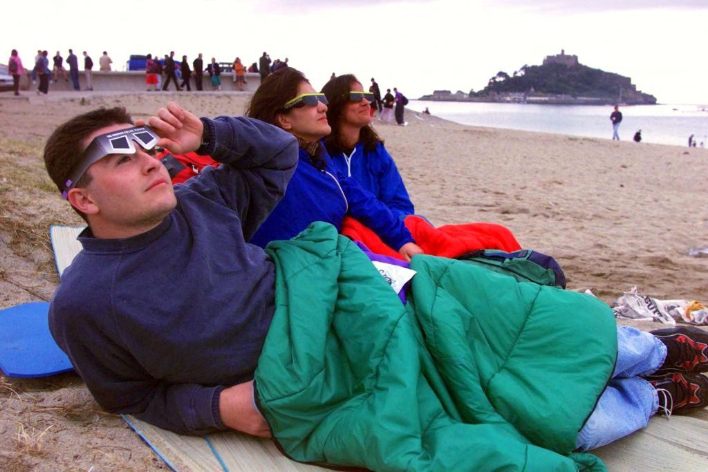 Three friends from Italy, who travelled especially to England to view the eclipse, wake up to cloud cover at Mounts Bay, Penzance, Cornwall, 1999