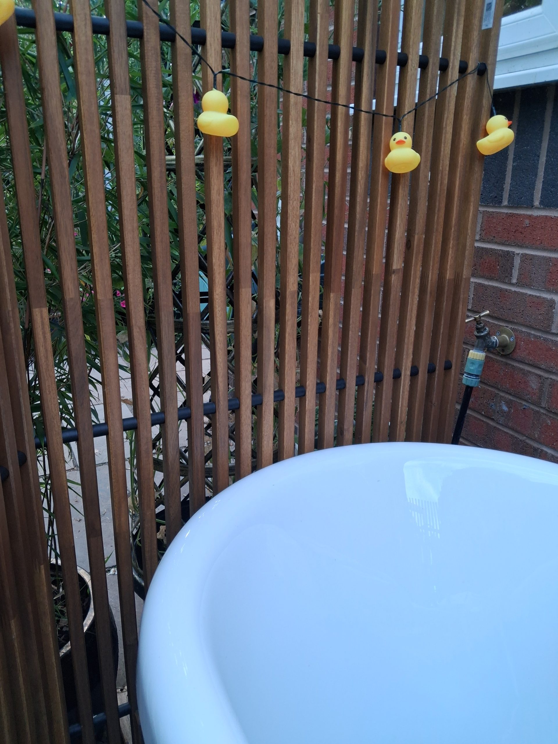 Erica's outdoor bathtub is lit with a string of solar-powered rubber duck lights