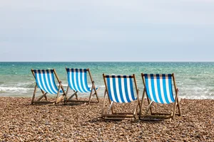Deck Chairs on a Beach A photograph of four empty deck chairs on the beach at Brighton, UK.