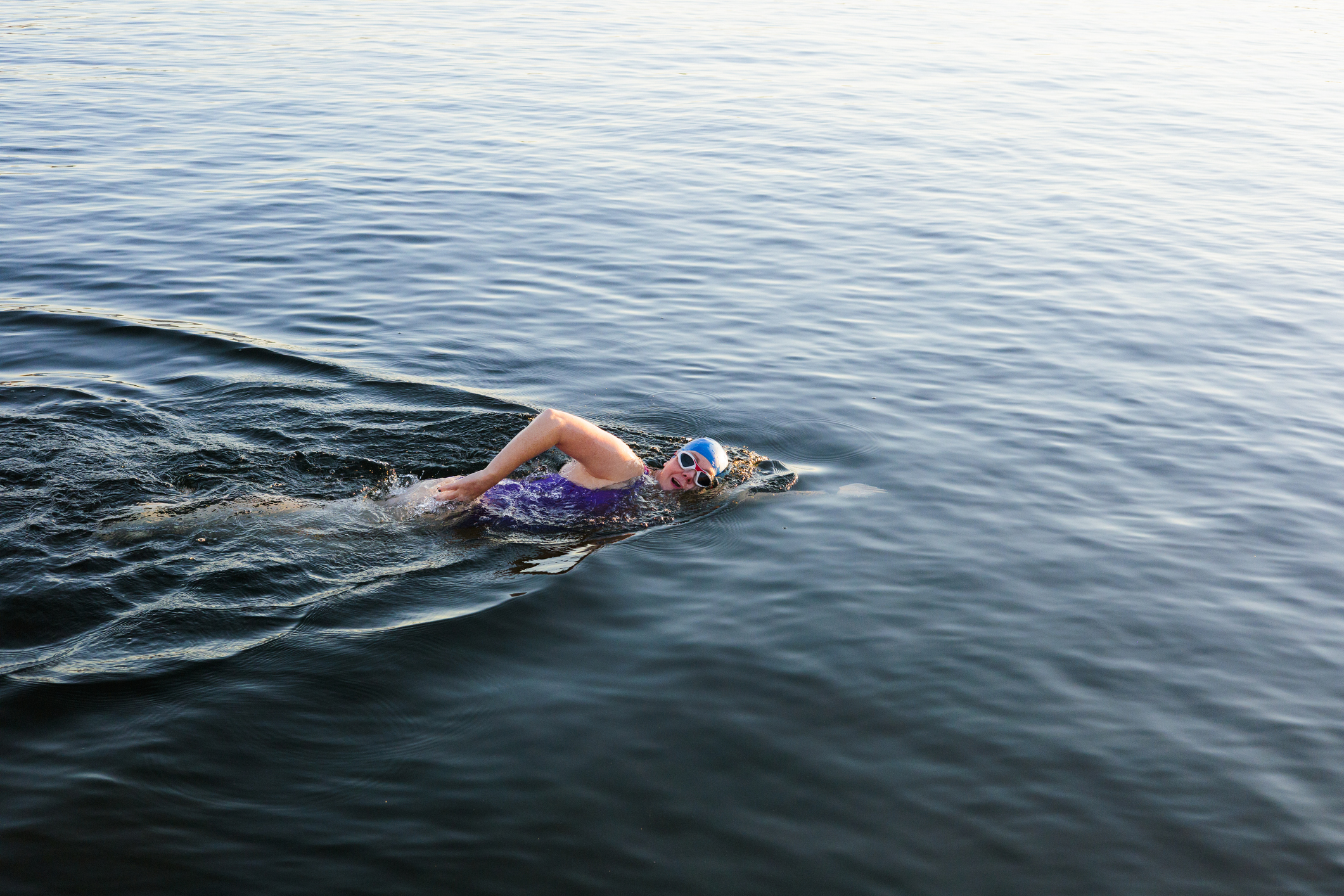 A woman swimming through a large body of water.