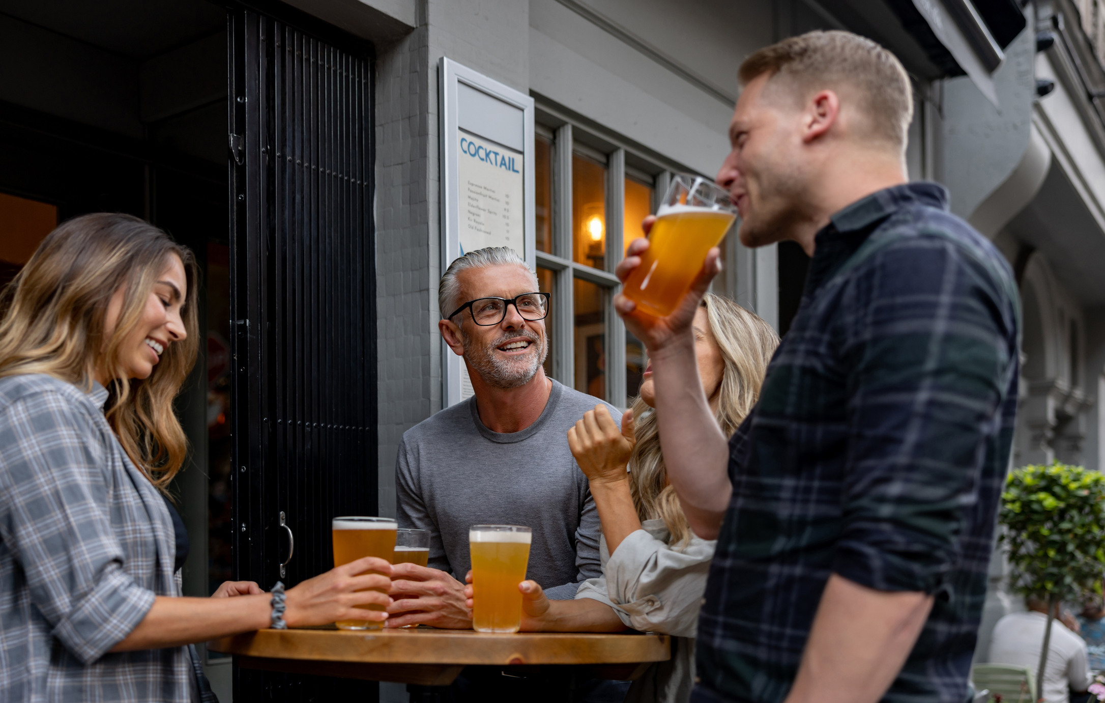 People stood outside a pub drinking together