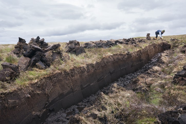Stacking peat on a bag in Scotland