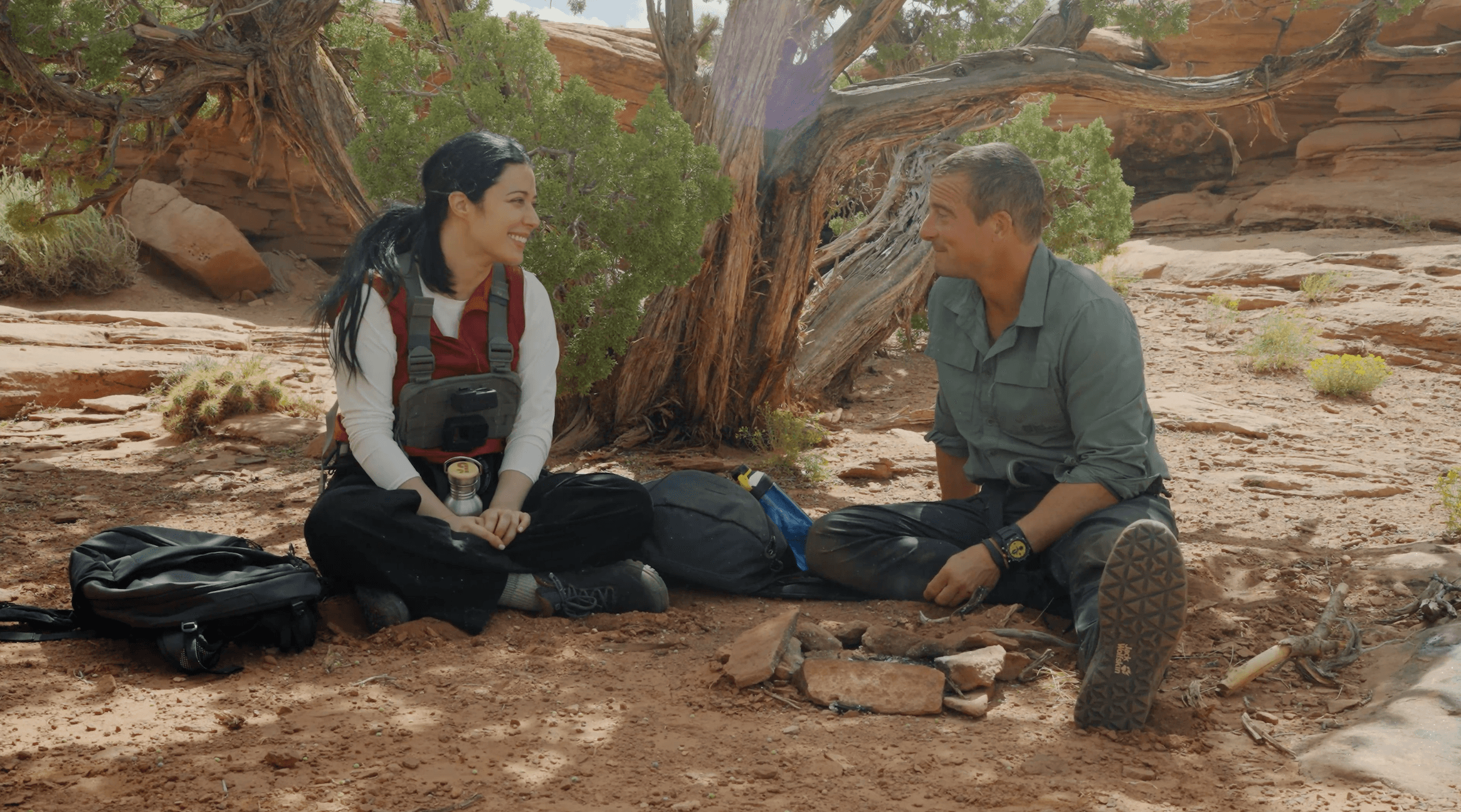 Elizabeth Tabish and Bear Grylls chatting underneath a tree