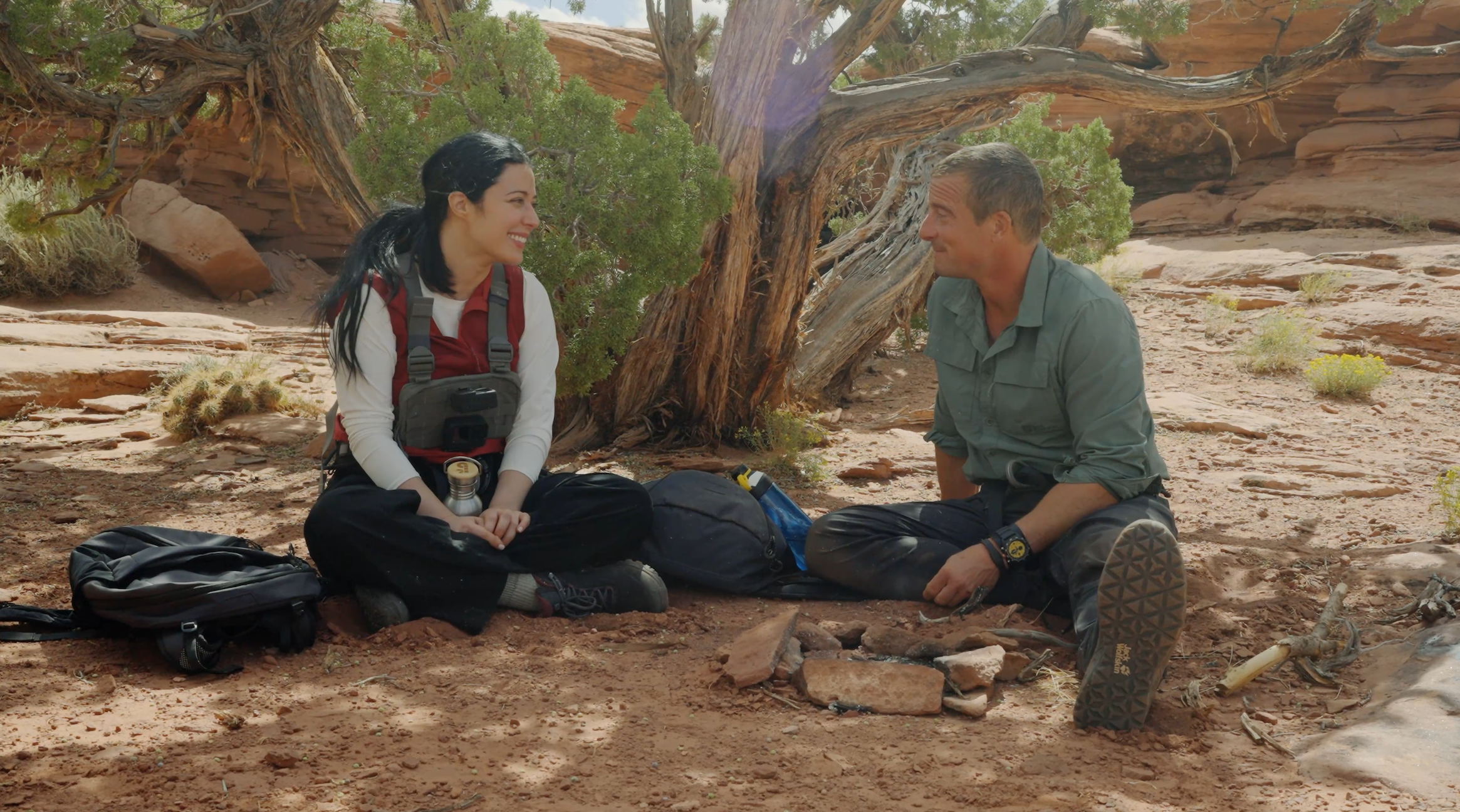 Elizabeth Tabish and Bear Grylls chatting underneath a tree